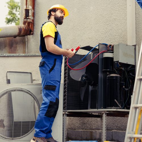 Meticulous workers diverse team doing routine air conditioner revision, assembling manometers. Competent mechanics checking for hvac system freon leaks leading to bad cooling
